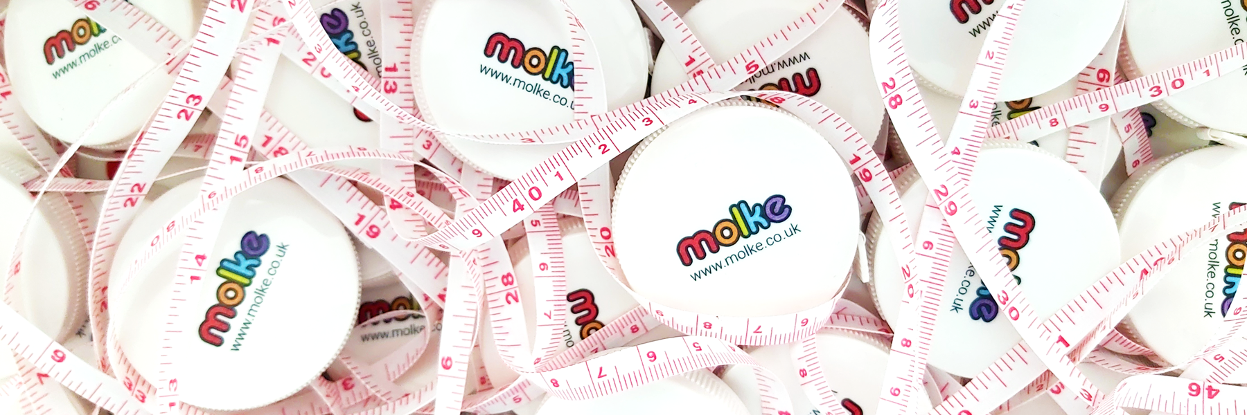 A pile of tangled measuring tapes with the Molke logo on the casing.