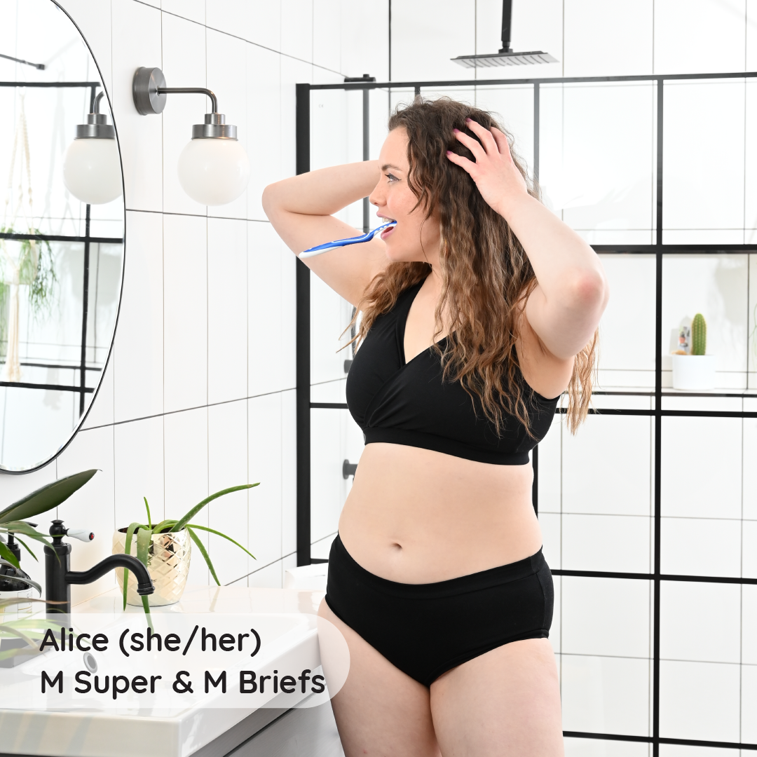 Alice is in a bathroom wearing a black non wired underwear set