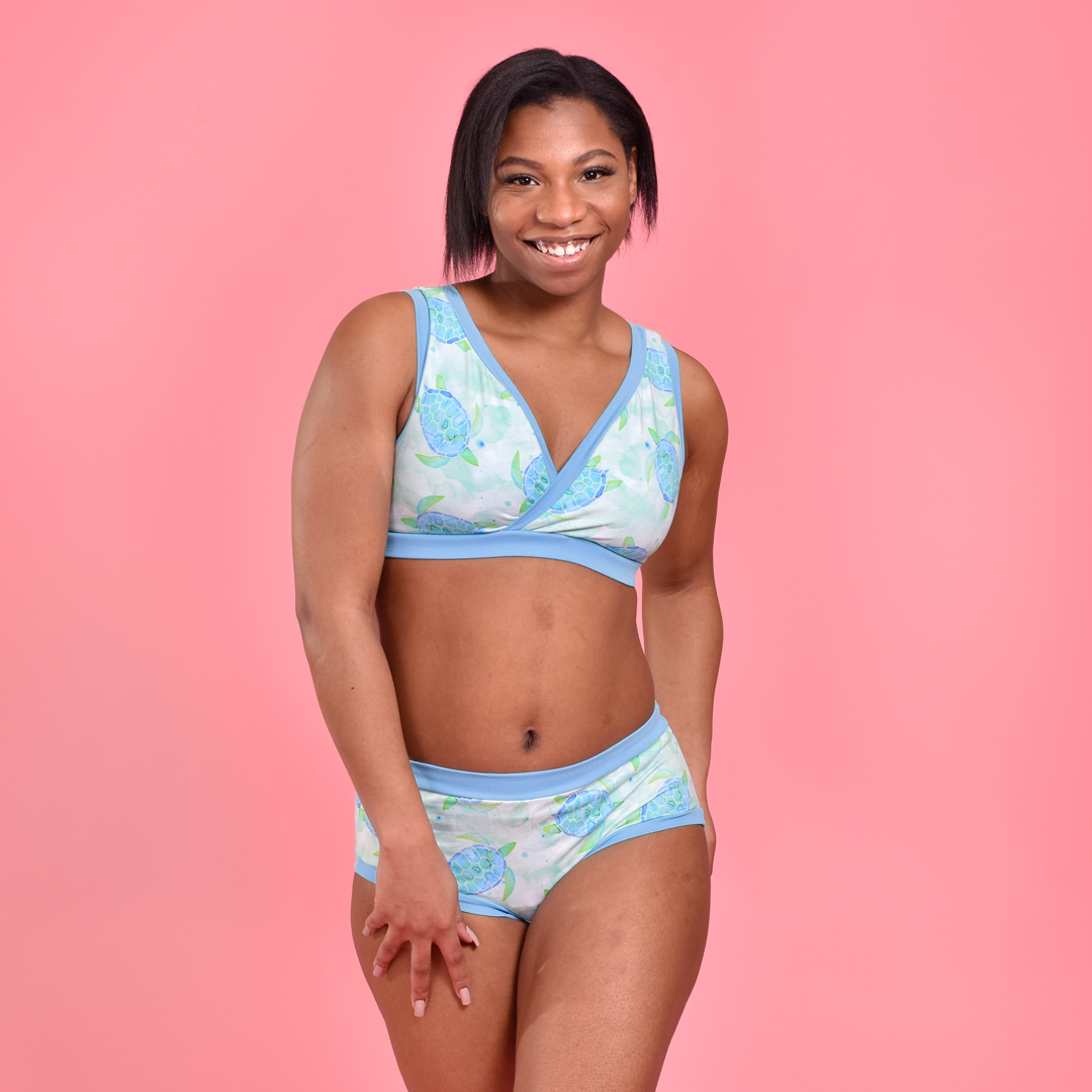 Precious is smiling and wearing a crossover style bra and mid rise briefs.