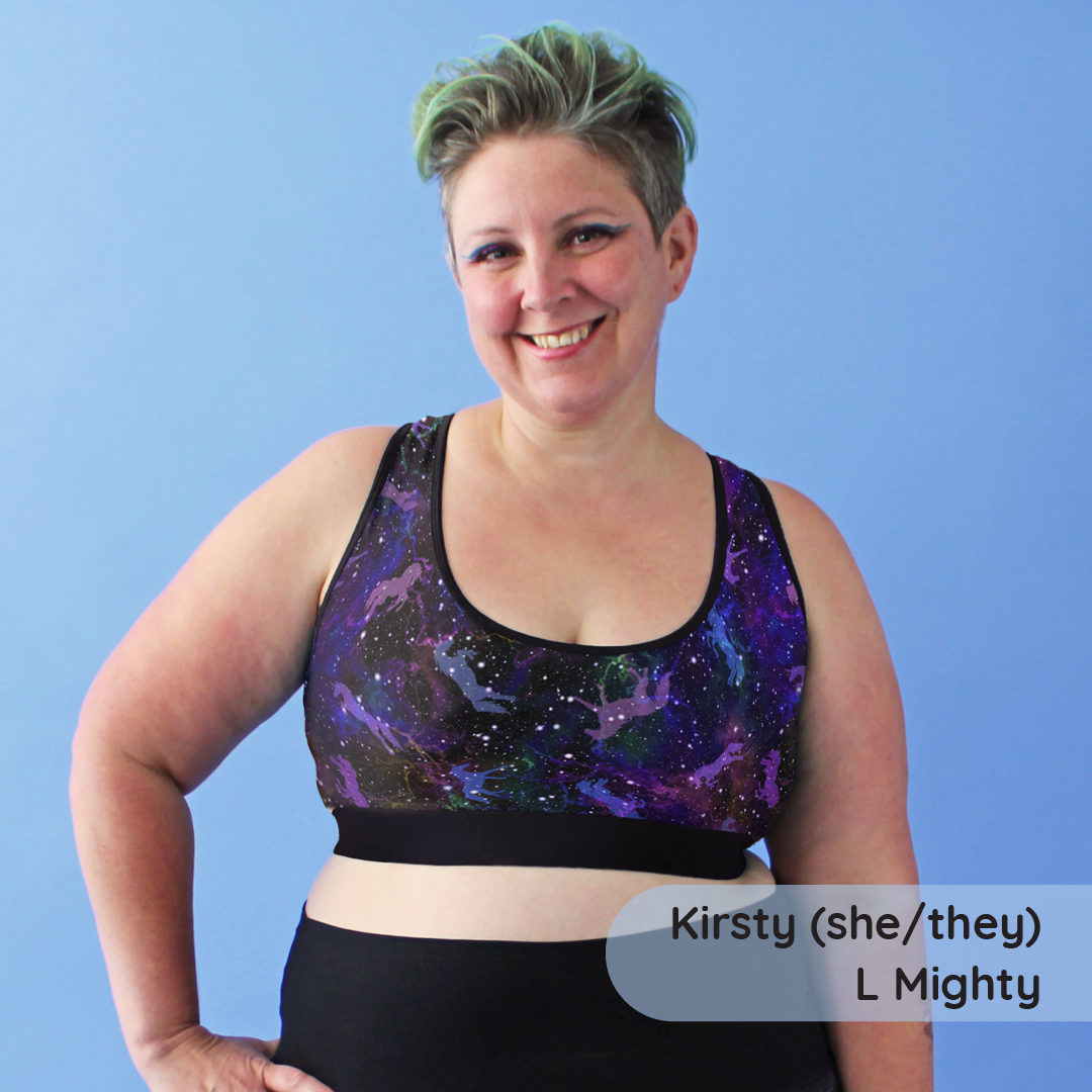 Person wearing a galaxy-patterned sports bra and black leggings on a blue background