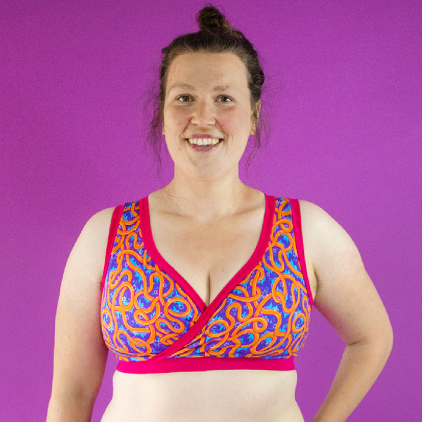 Close crop of Katy wearing a pink, orange purple and blue patterned non wired bra