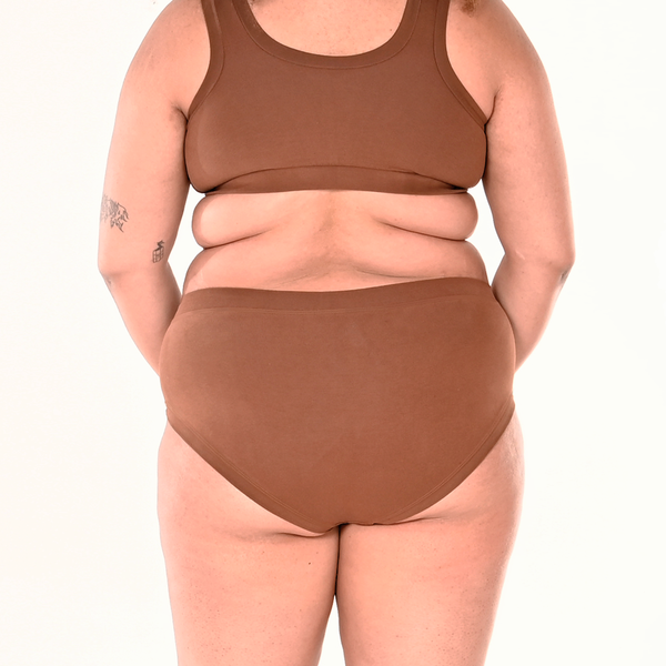 Back view of Tumi wearing mid rise skin tone brown underwear