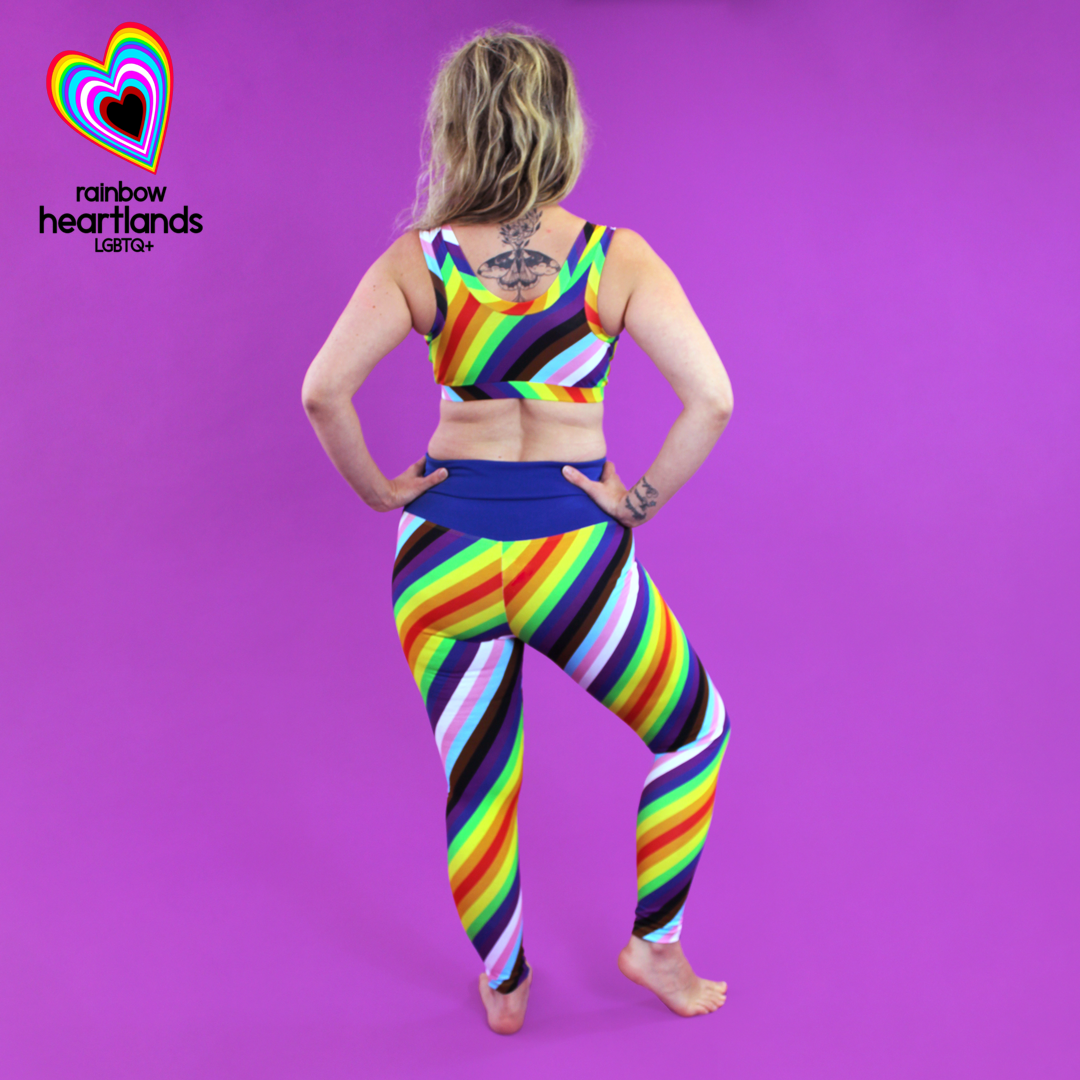 Back view of Ros wearing rainbow pride leggings and bra