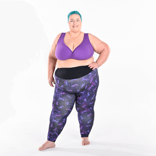 Estelle is standing wearing a purple bra and universe leggings