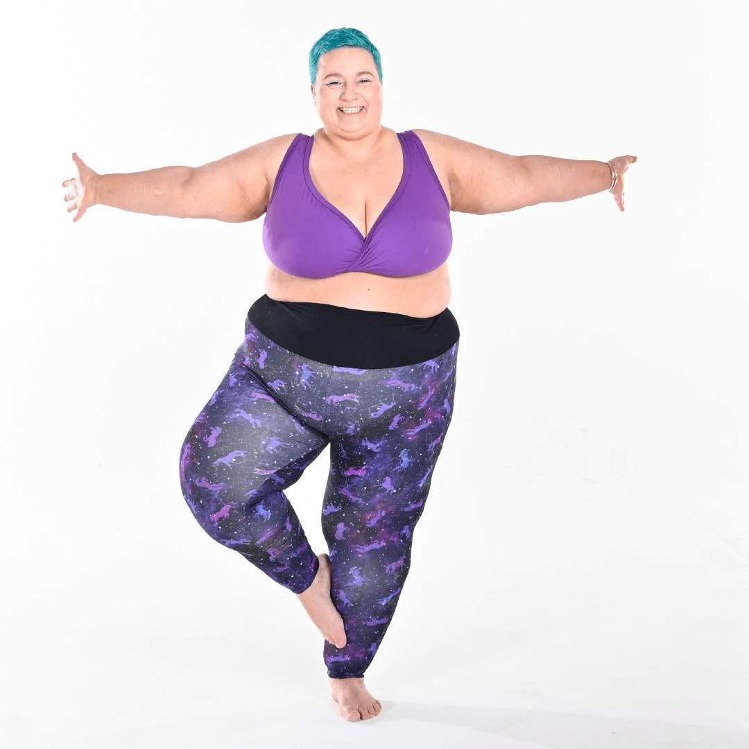 Estelle has her arms out balancing wearing universe leggings and a purple bra