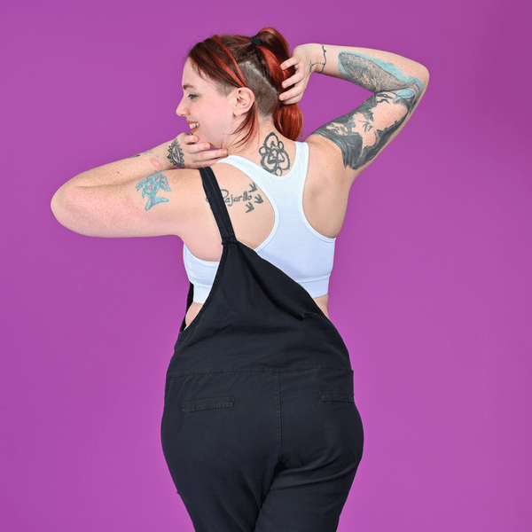 back view of Eilidh wearing a white racerback bralette and dungarees