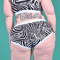 back view of model wearing a mid rise zebra print briefs and bra