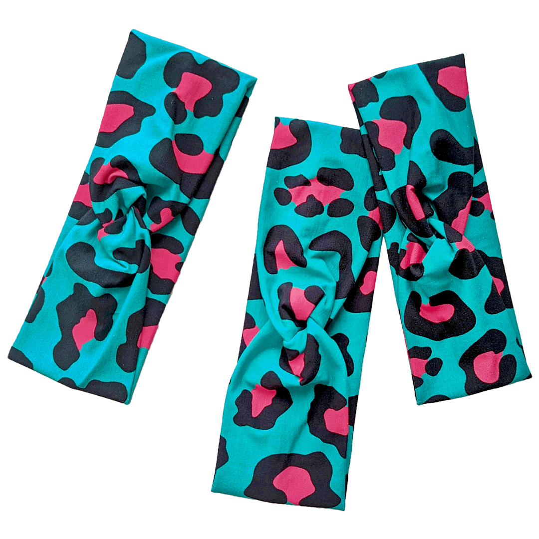 Flat lay of 3 teal and hot pink leopard print headbands