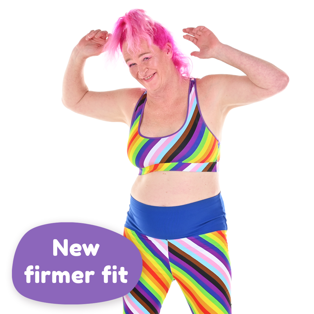 Oceana is posing in a Pride bralette and leggings. There is a purple oval with 'New Firmer Fit' in it.