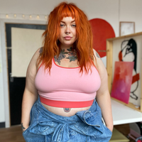 Taynee is wearing a candyfloss pink bralette and jeans