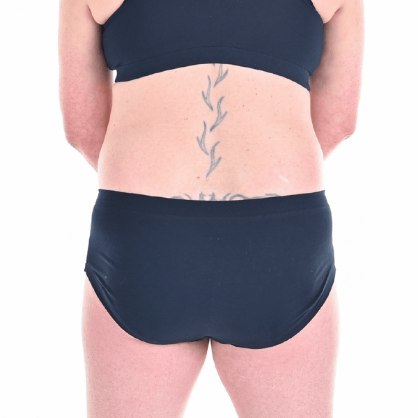 Back cropped view of Oceana wearing Navy mid rise briefs and bra