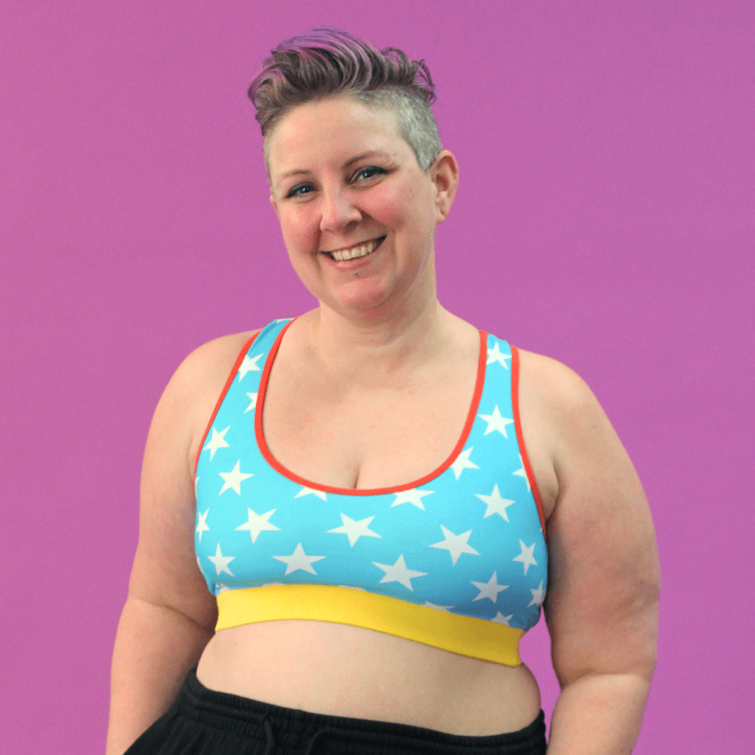 Kirsty is wearing a wonderwoman bralette which is blue with white stars and a red and yellow trim