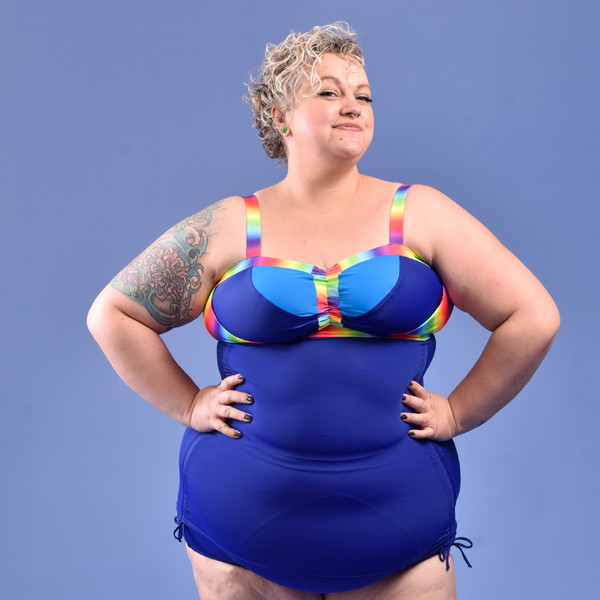 Claire is wearing a blue rainbow tankini and swim briefs
