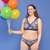 Alice is wearing a colourful underwear set holding balloons.